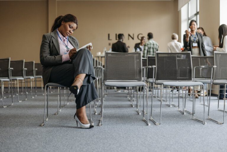 A professional woman takes notes during a break in a business seminar.